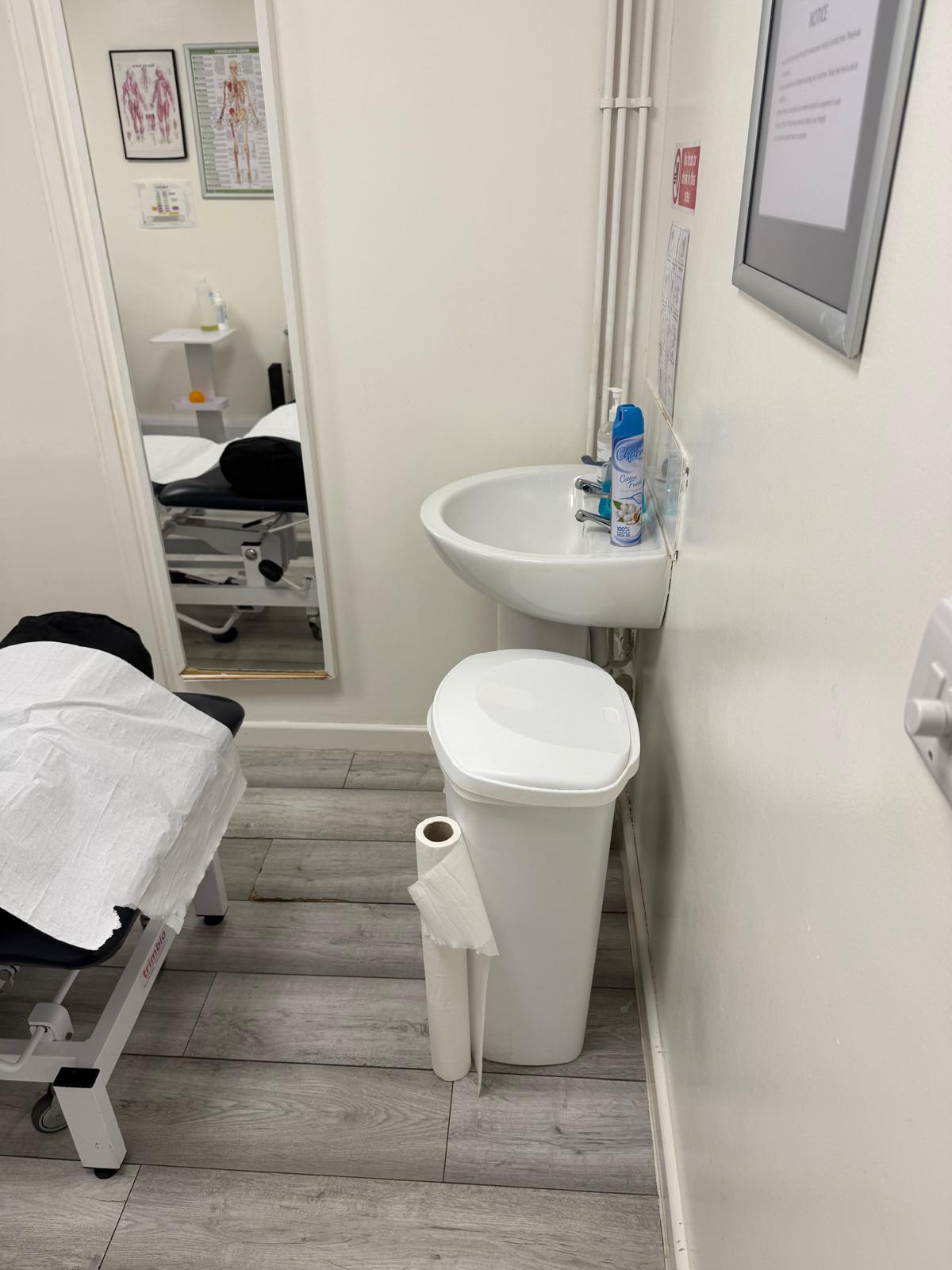 Clinical treatment area with washbasin at PC Physiotherapy Newport Pagnell — standard clinical hygiene facilities for private healthcare